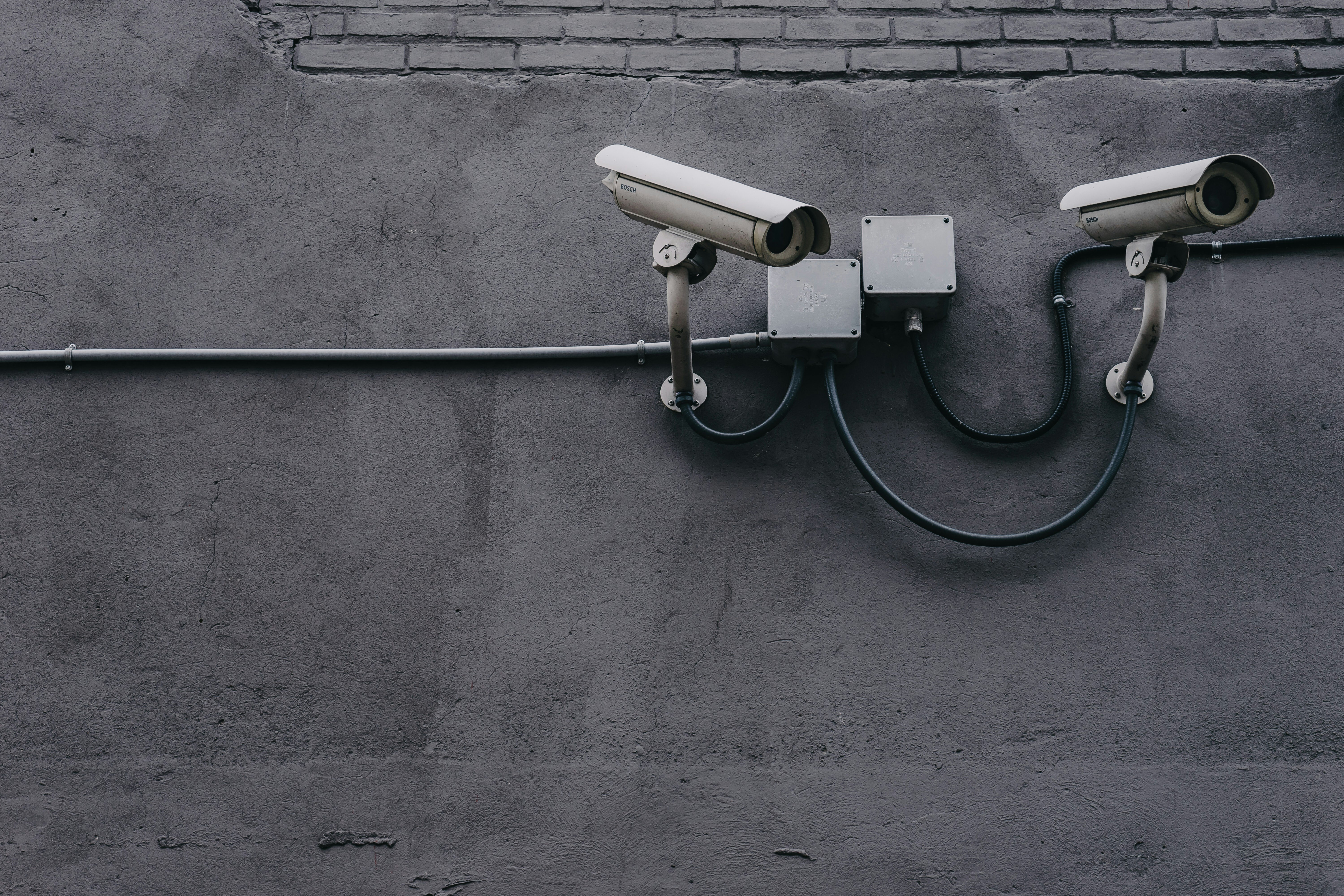 Two security cameras mounted on a wall.